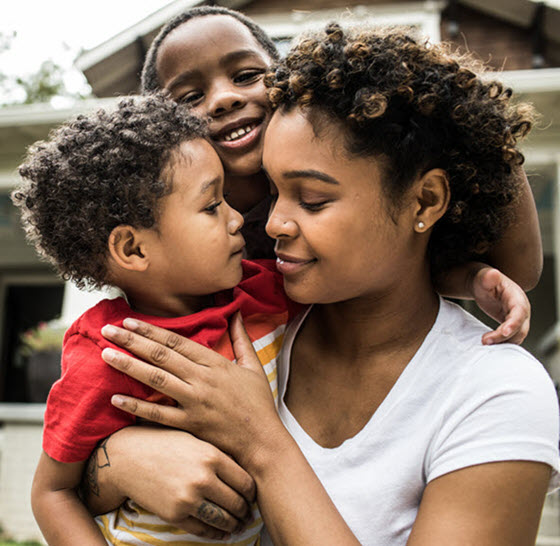 Mother with two children in arms and hugging